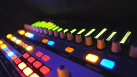 Close up of soundboard with knobs and green color equalizer in night club. View on audio waves or music control levels at professional sound equipment. Slow motion - Powered by Shutterstock - Get 15% off with code: PIKWIZARD15