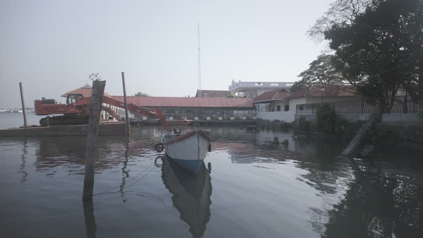 A calm morning scene of a small boat docked near Mumbai