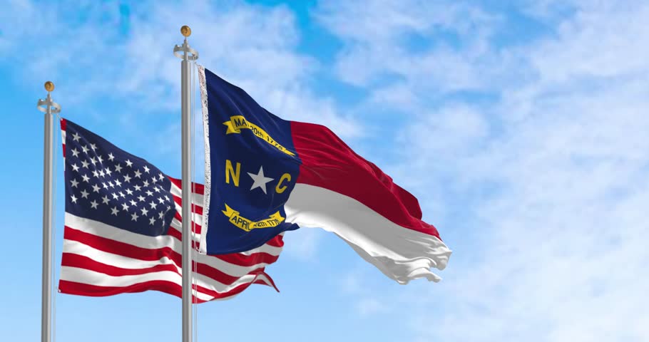 North Carolina state flags waving with american flag. North Carolina is a state in the Southeastern region of the S. Rippled fabric. Seamless 3d render animation. Slow motion loop. Selective focus
