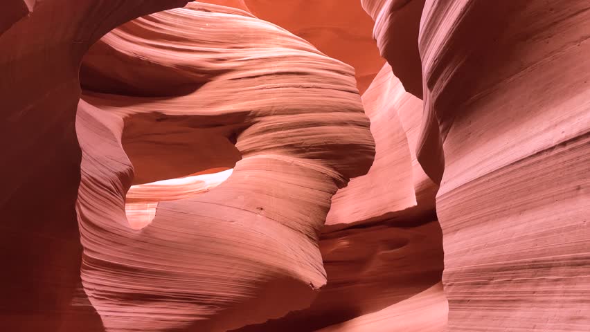 Experience the breathtaking beauty of Antelope Canyon, where sunlight illuminates swirling sandstone formations, creating mesmerizing patterns and vibrant colors, especially enchanting at midday.
