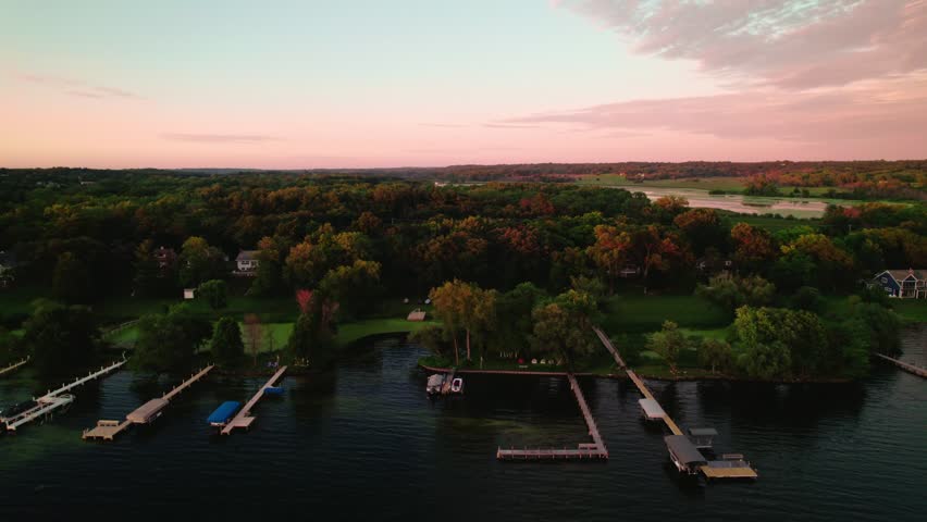 Aerial view during dusk over houses near the water at Green Lake Inlet Boat Launch Site in Ripon, Wisconsin. Serene residential living by the lake as day transitions into night.