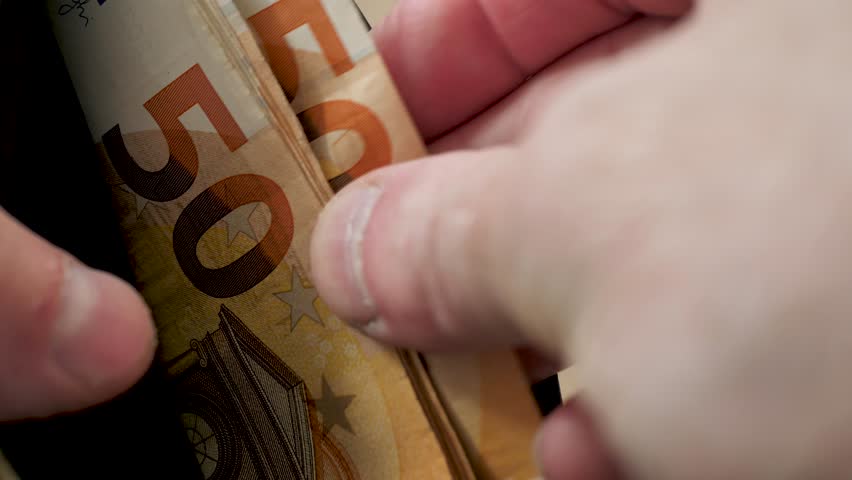 Man's fingers count euro notes in his wallet or purse. Man counting remaining banknotes in his leather wallet. Close-up of counting notes. Low wages and benefits for refugees. Financial growth