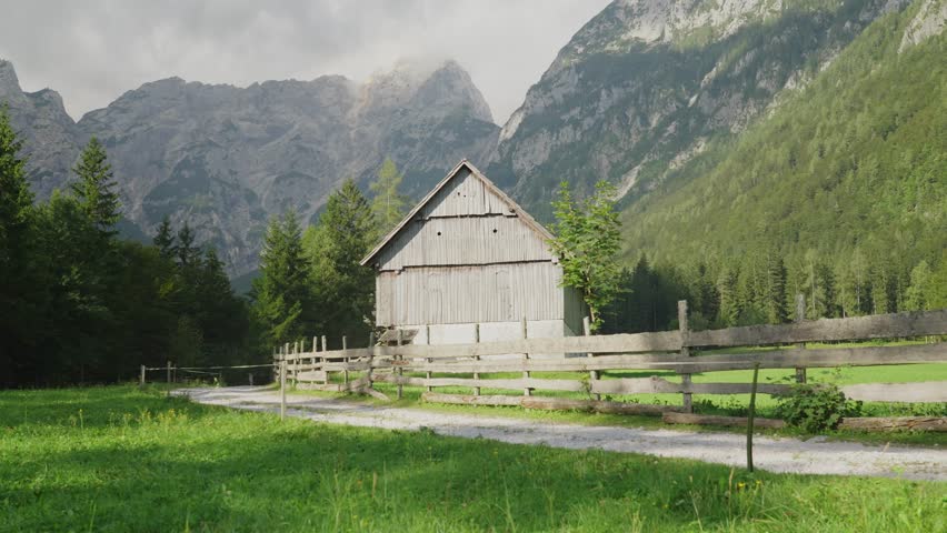 A couple hikes past an old farm in the scenic Robanov Kot valley surrounded by mountains