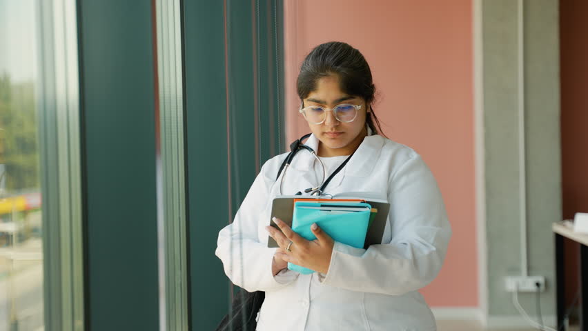 Indian medical student prepares for upcoming exams by reading study materials