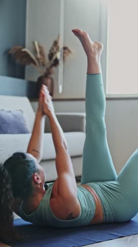 Woman performing bicycle crunches on a mat in a living room, focusing on core strength and abdominal muscles. Woman performing bicycle crunch exercise at home