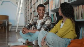 African American man Hispanic Indian woman students classmates talking sitting on floor library together female male communicate university friends chatting discussion smile laugh two people educate - Powered by Shutterstock - Get 15% off with code: PIKWIZARD15