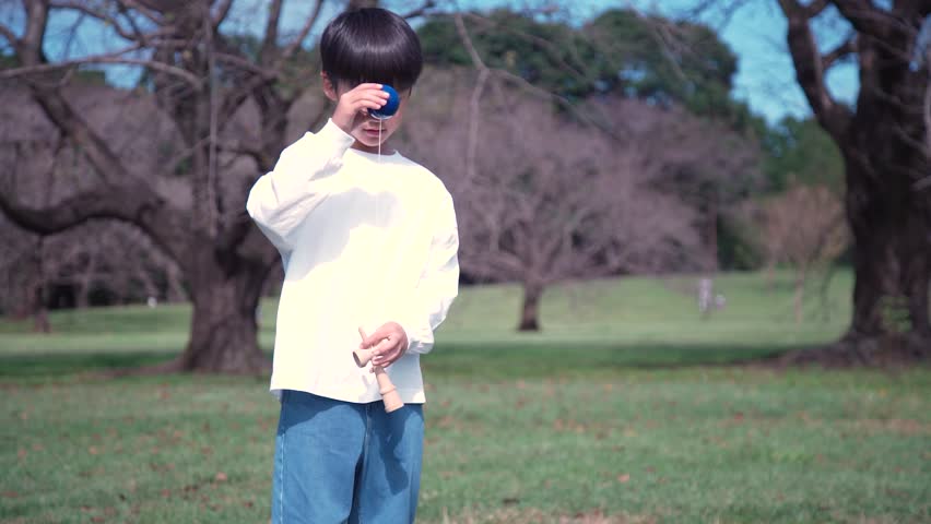 Image of a boy practicing Kendama
