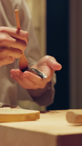 Sushi, hands and cooking with person in restaurant for traditional menu, seafood and Japanese cuisine. Itamae, fish sashimi and closeup of chef and soy glaze for catering, culture or gourmet