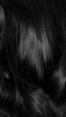 Closeup vertical long hair texture in slow motion, black curly hair background