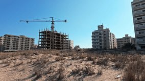 Abandoned buildings with construction crane in Varosha under clear blue sky - Powered by Shutterstock - Get 15% off with code: PIKWIZARD15