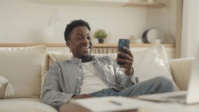 African American male person chatting in mobile app by video call, smiling face. Young adult black guy talking with friends online, distant communication in social media, modern applications in phone - Powered by Shutterstock - Get 15% off with code: PIKWIZARD15