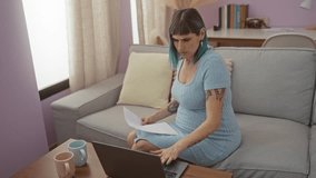 Pregnant woman with blue hair sitting on couch working on laptop with supportive man in cozy indoor living room setting - Powered by Shutterstock - Get 15% off with code: PIKWIZARD15