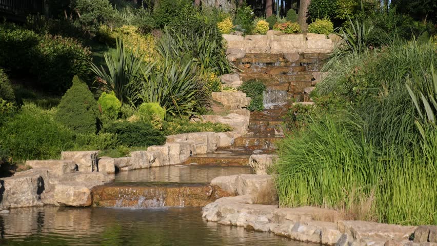 An incredibly serene waterfall landscape set within a lush and vibrant green garden
