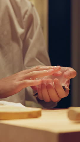 Sushi chef, hands and fish in rice preparation in restaurant for traditional Japanese cuisine and cooking. Kitchen, culinary artist and gourmet tuna ingredients for seafood snack, nutrition and meal