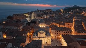 Aerial Nighttime View of Dubrovnik's Old Town, Croatia. Fly around Cathedral of the Assumption of the Virgin Mary in Dubrovnik with city lights at sunset - Powered by Shutterstock - Get 15% off with code: PIKWIZARD15