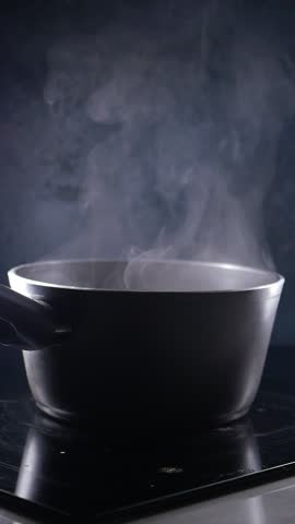 Steam Rising Up from a Black Cooking Pot Sitting on a Stove in a Cozy Kitchen Environment