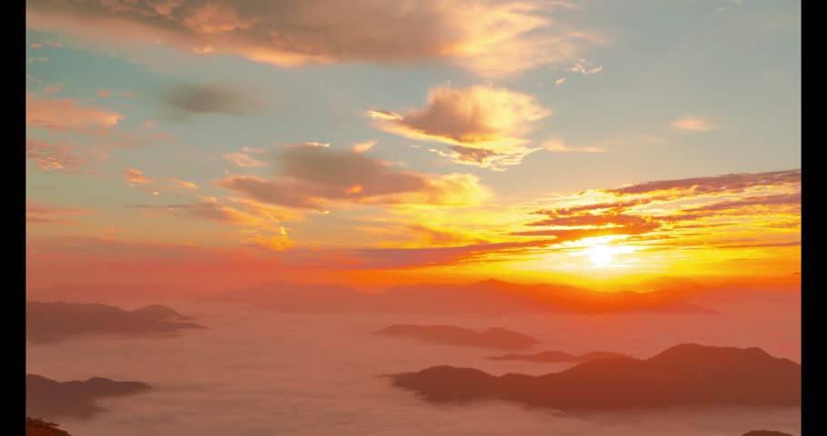 The soft morning sunrise illuminates Cheonmasan Mountain, as white mist gently drifts over the autumn landscape. The serene wind enhances the cinematic, horizontal view, capturing nature’s quiet beaut