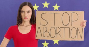 Woman holding stop abortion sign and hand against background of eu flag 4k movie slow motion. Women protests and human rights concept - Powered by Shutterstock - Get 15% off with code: PIKWIZARD15