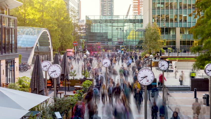Sunrise timelapse view of motion blurred business people rushing to work in the moring at the financial centre Canary Wharf, London
