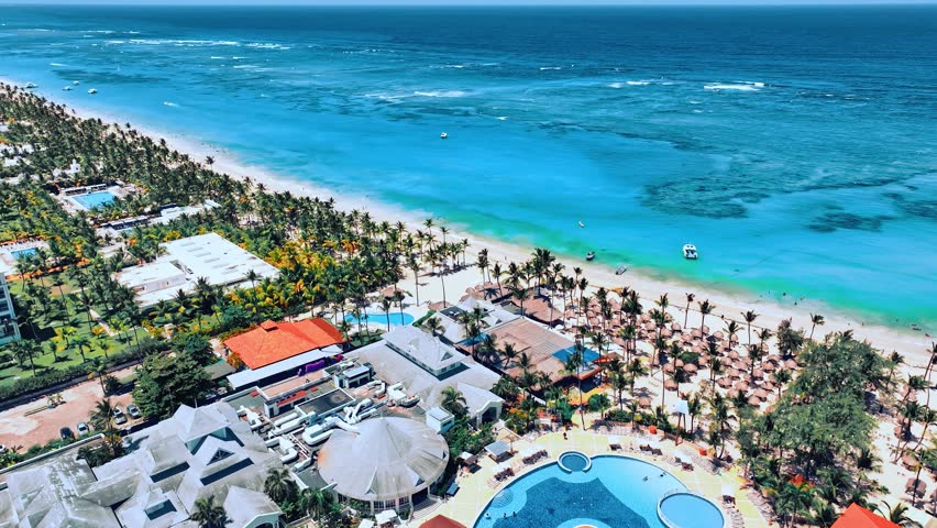 Many resort hotels with palm sand beach on the sea coast. Tropical oasis and travel destination. Best place for summer vacation. Blue ocean on a sunny day. Summer vacation concept.