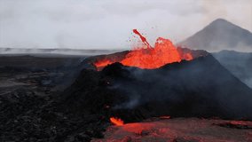 A volcano erupts in Iceland, spewing molten lava and ash, with lava flowing down the rugged volcanic landscape. Smoke and ash rise into the sky. - Powered by Shutterstock - Get 15% off with code: PIKWIZARD15