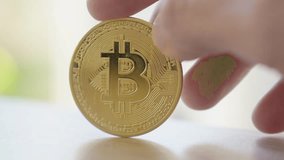 Slow motion shot of a bitcoin cryptocurrency coin spinning in a persons fingers - Powered by Shutterstock - Get 15% off with code: PIKWIZARD15