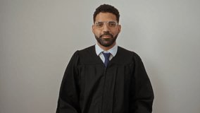 Judge gown, young hispanic man standing confidently, pointing and smiling with thumbs up behind on isolated white background - Powered by Shutterstock - Get 15% off with code: PIKWIZARD15