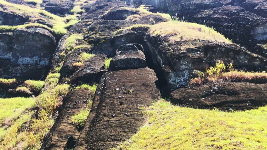 Moai under construction in a beautiful sunny landscape over Ranu a Raraku in a summer day in Easter Island, Rapa Nui, Polynesia, Chile, Latin America.
