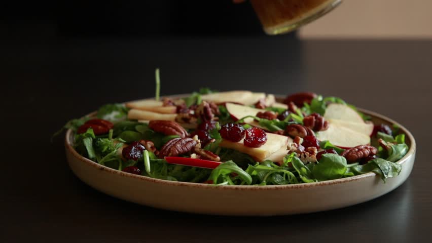 Dressing Fall Salad with Arugula, Apples, Dried Cranberries, and Pecans - Close-Up