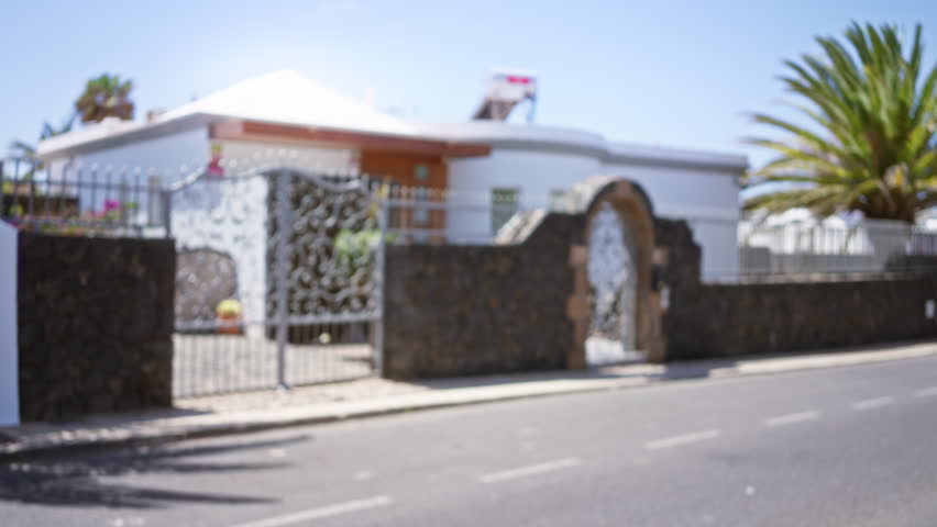 Blurred view of a residential house with ornate gate on a sunny day in lanzarote, canary islands, spain.