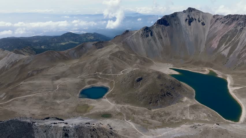 Backward drone flight over Nevado de Toluca, revealing Laguna del Sol and Laguna de la Luna in Mexico.