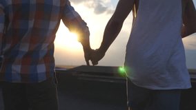 Camera follow gay couple runs on roof holding hands of each other at evening time. Friends spending time together outdoor. Concept of male friendship. Rear back view Slow motion Close up - Powered by Shutterstock - Get 15% off with code: PIKWIZARD15