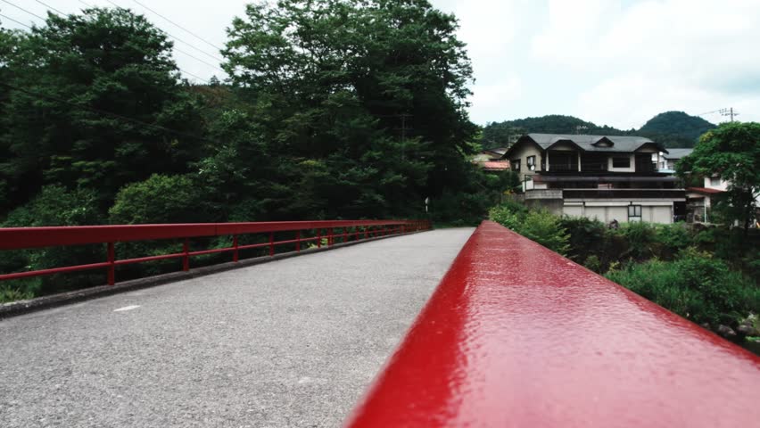 4k cinematic footage of a men crossing a japanese bridge