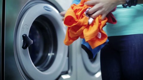 Woman putting clothes in the washing machine