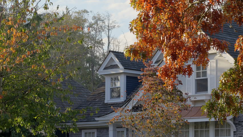 Establishing shot. Two story stucco luxury house with garage door, big tree and nice Fall Foliage landscape in Vancouver, Canada, North America. Day time on Sept 2024. ProRes 422 HQ.