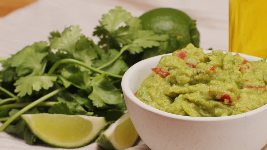 Guacamole dip, traditional mexican food in restaurant for nachos, close up of avocado plate for vegetarians.