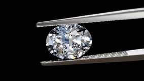 Brilliant oval cut diamond swaying slightly in tweezers, close up view on deep blue background. Seamless loop 3D animation. - Powered by Shutterstock - Get 15% off with code: PIKWIZARD15