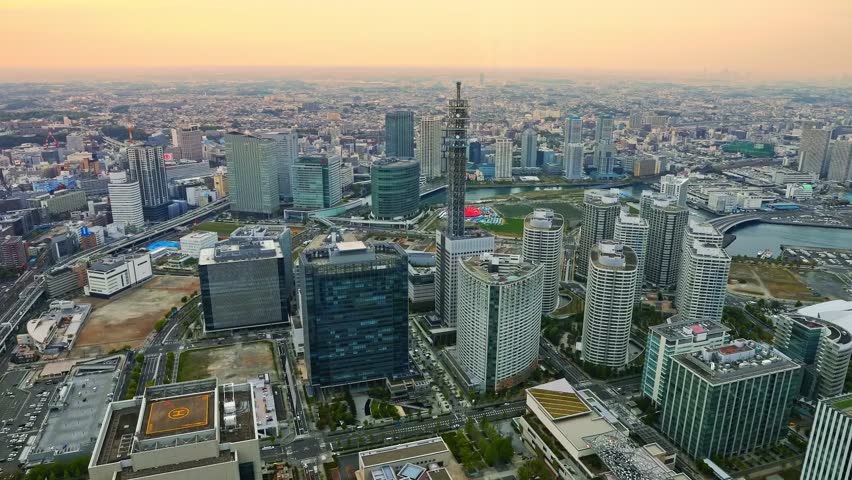sunset aerial view of Yokohama Cityscape and Yokohama Skyline at night from viewing platform of Landmark Tower. Skyscrapers from observatory sky garden. Illuminated railway and subway. TIMELAPSE