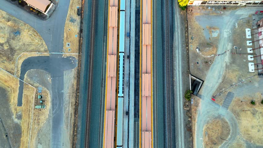 Aerial footage of a stationary train at the Sacramento Amtrak station, capturing the detailed view of the train tracks and urban surroundings from above