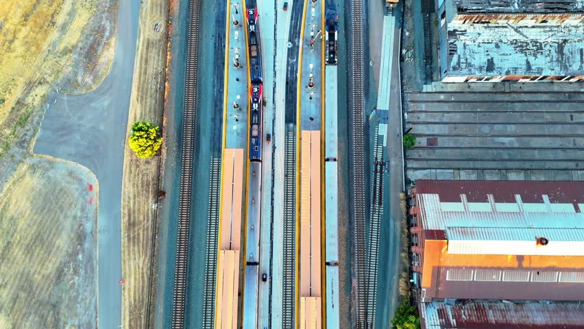 Aerial footage of a stationary train at the Sacramento Amtrak station, capturing the detailed view of the train tracks and urban surroundings from above