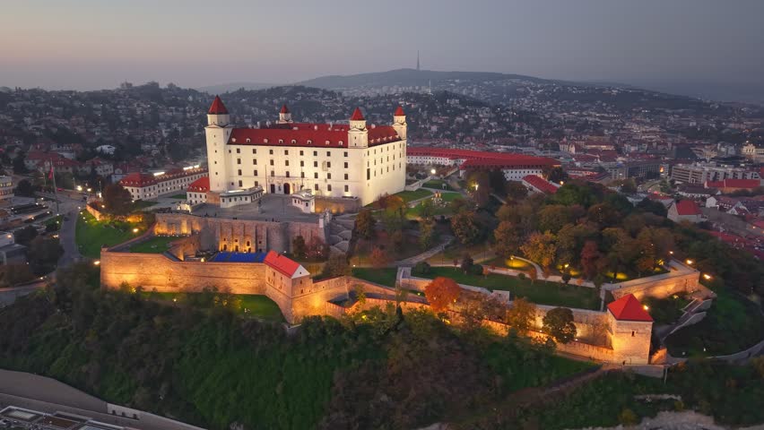 Aerial shot of Bratislava Castle or Bratislavsky Hrad with city light in Bratislava, Slovakia. Sunset viev, UHD, 4K