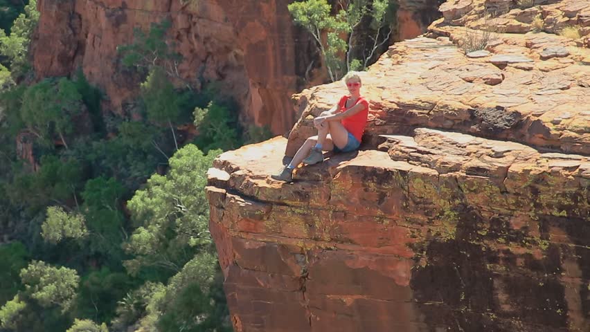 Caucasian tourist girl looking panoramic views of Kings Canyon in Watarrka National Park, Australia