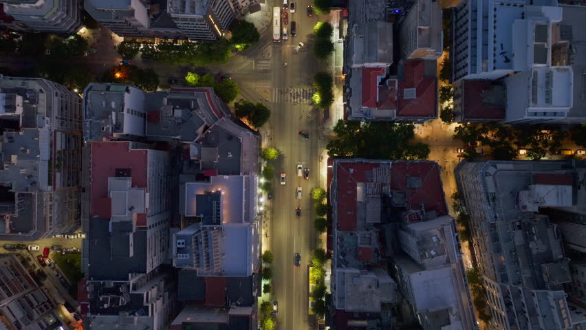Aerial view above the urban center of Thessaloniki, Greece. Cars drive down multi lane avenues lined with illuminated buildings