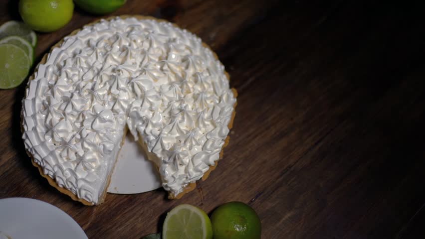 Beautiful composition of a lemon pie on a wooden table with lemons to decorate