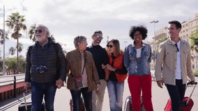 Group of smiling mature people walking carefree with their luggage enjoy vacations on street of Barcelona city. Diverse happy middle-aged friends celebrating leisure time on spring sunny day - Powered by Shutterstock - Get 15% off with code: PIKWIZARD15