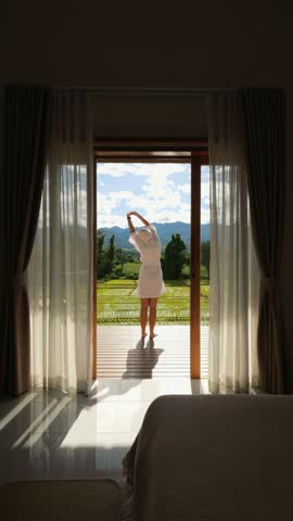 Luxury Villa Morning: Woman In White Bathrobe Opening Curtains With Scenic Rice Field View