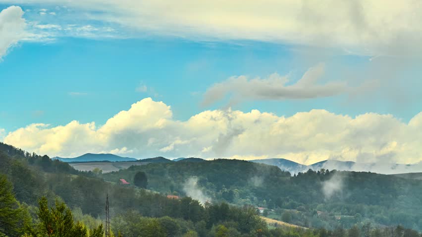 Nature landscape cumulus clouds rolling over hills and mountains time-lapse
