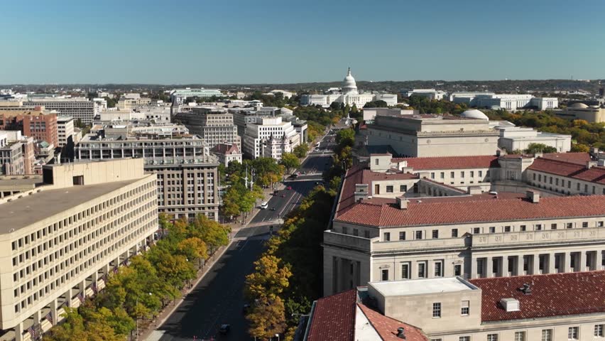 Aerial view of US Capitol and Washington DC looking down Pennsylvania Avenue with buildings, streets and traffic.