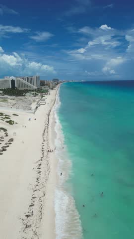 Aerial Top view of a transparent blue sea with beautiful waves at sunny day in summer. Tropical landscape from the air of ocean with azure water, sandy bottom at sunset. Cancun, Mexico.
