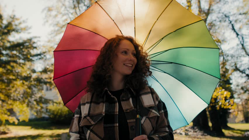 Woman with colorful umbrella enjoying a sunny autumn day